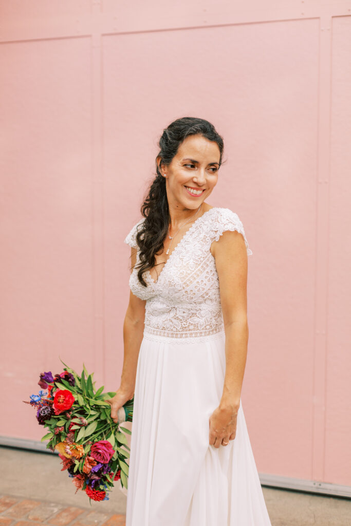 bride in short sleeve lace bodice wedding dress and bright bridal bouquet at Grass Room 