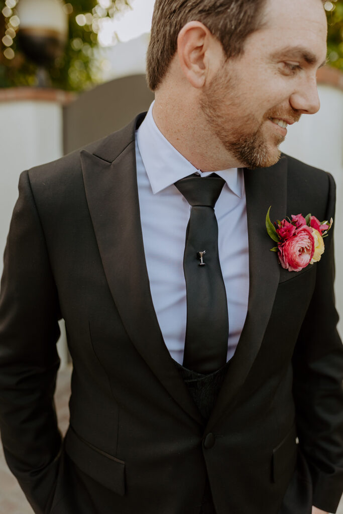 groom in black suit and martini glass tie pin 