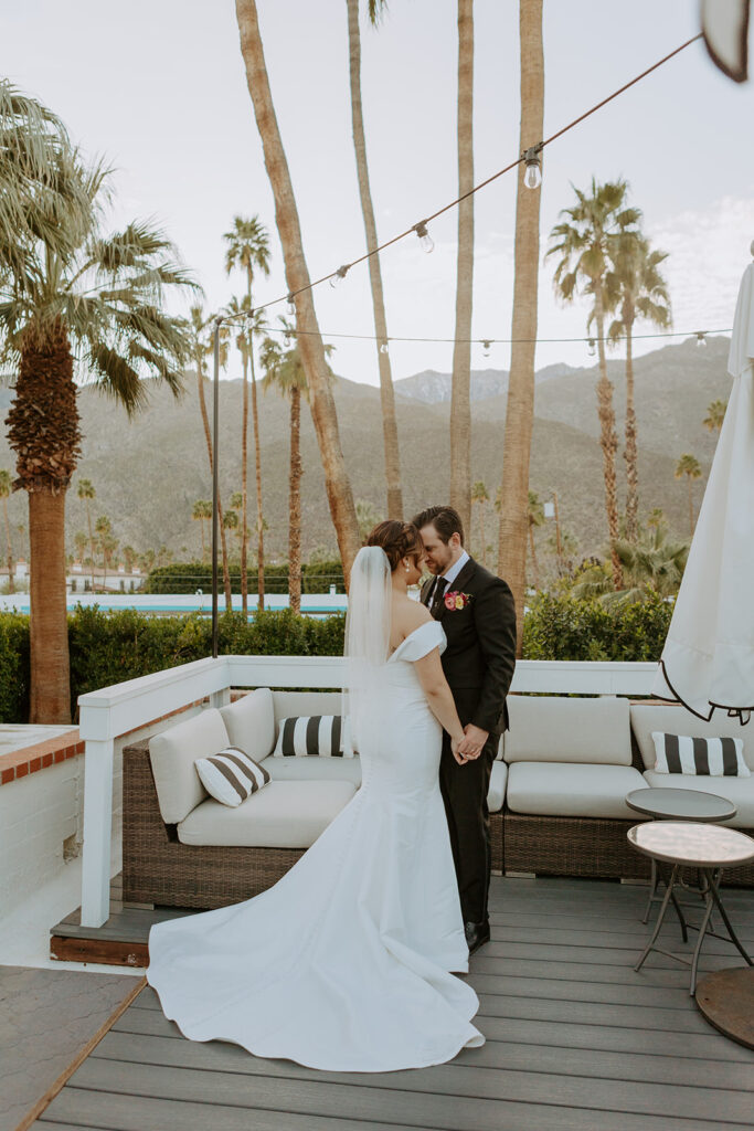 bride in minimalist off shoulder wedding dress and groom in black suit sunset photos in Palm Springs