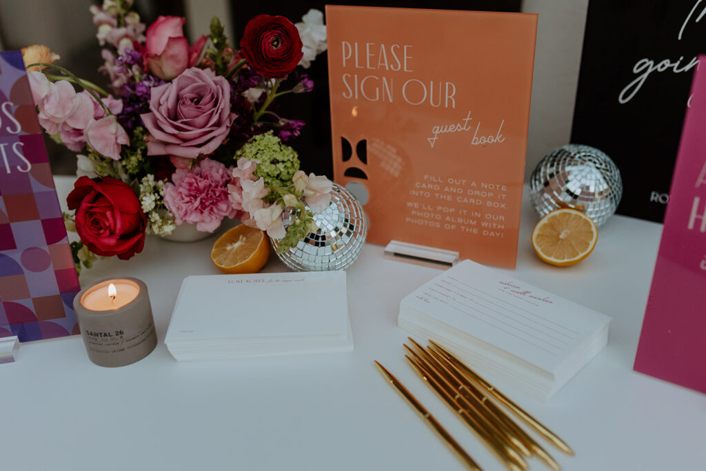 mid-century inspired guest book sign with gold pens and disco ball decor