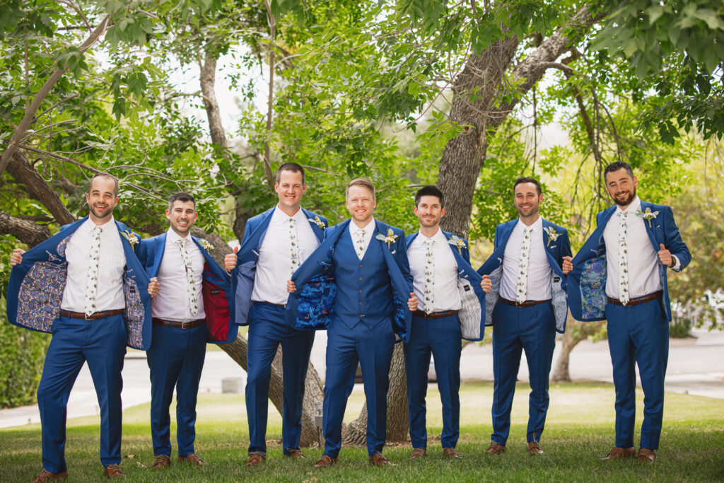 groom and groomsmen in blue suits and billy ball boutonnieres