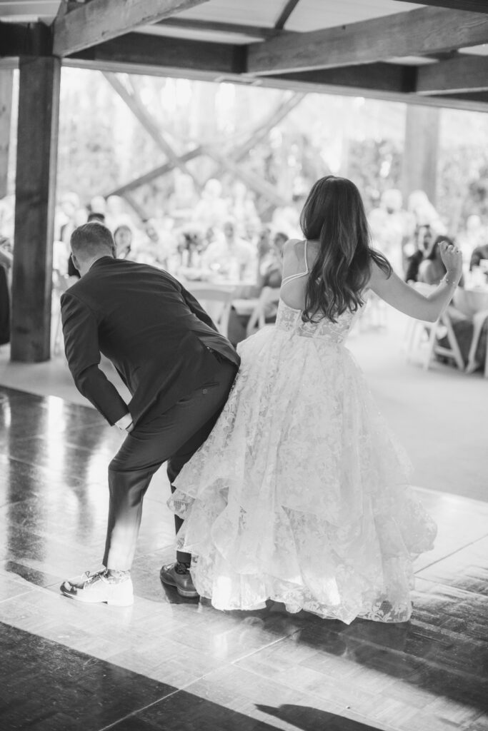 bride in tiered lace wedding dress with groom in blue suit first dance at the Oak Room at Calalmigos Ranch