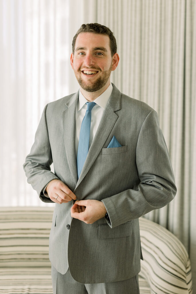 groom in light grey suit with blue tie