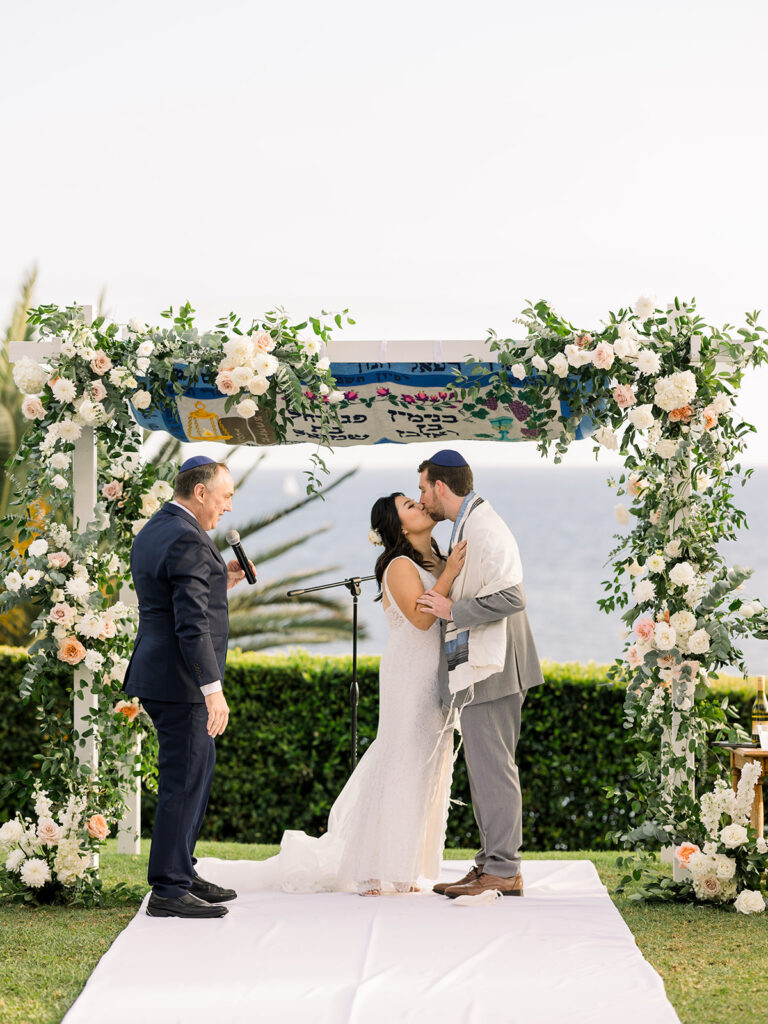 bride and groom first kiss during wedding ceremony at Bel Air Bay Club