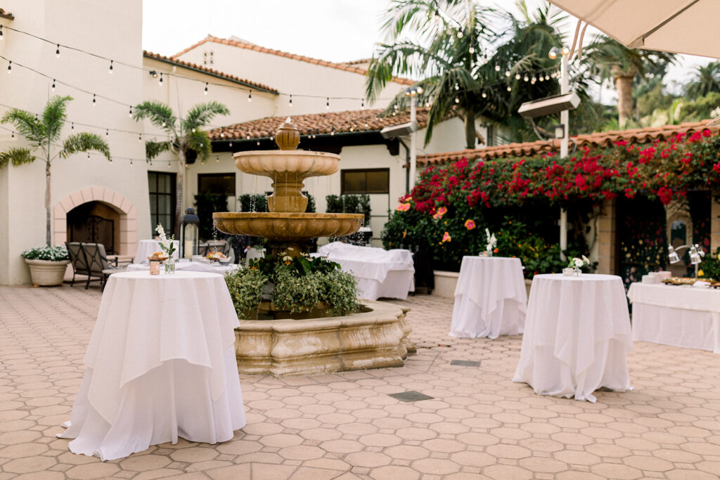 outdoor wedding cocktail hour around stone fountain at Bel Air Bay Club