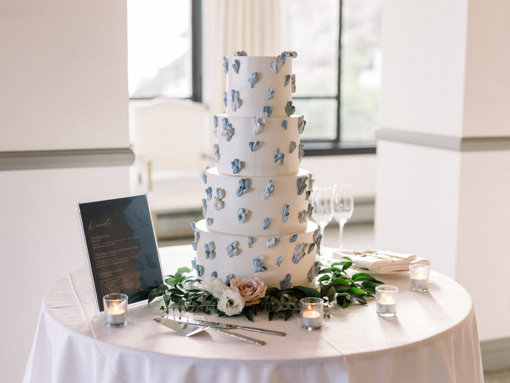 4 tier classic wedding cake with blue buttercream frosted flowers