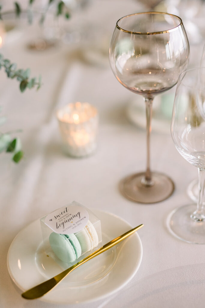 wedding reception at Bel-Air Bay Club with timeless wedding colors of white, blue and green with small box of macarons as guest favors with sticker that reads a sweet ending to a new beginning