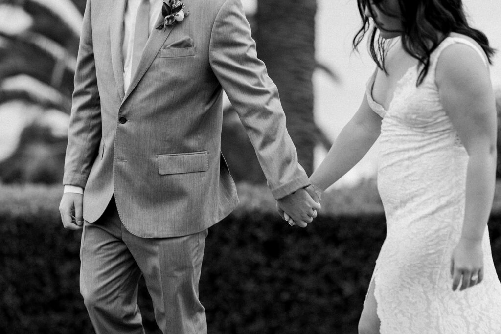 black and white photo of bride and groom holding hands