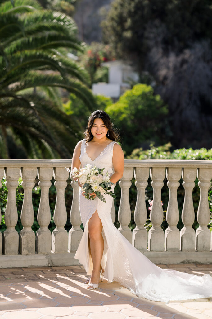 bride in deep v-neck lace dress with leg opening and long train at Bel Air Bay Club