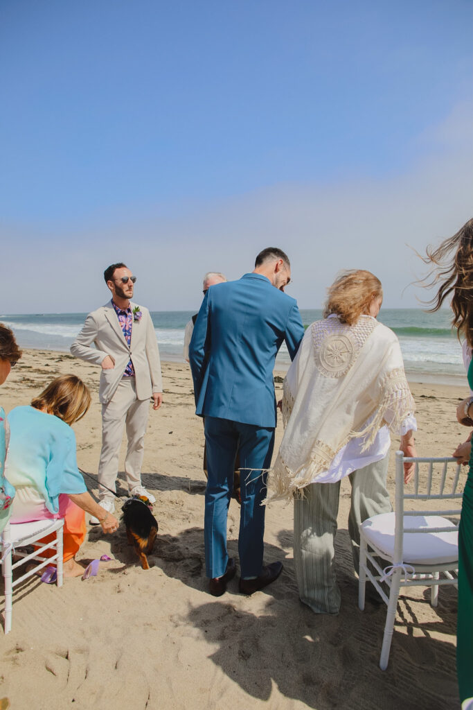 grooms get married during private beach wedding ceremony