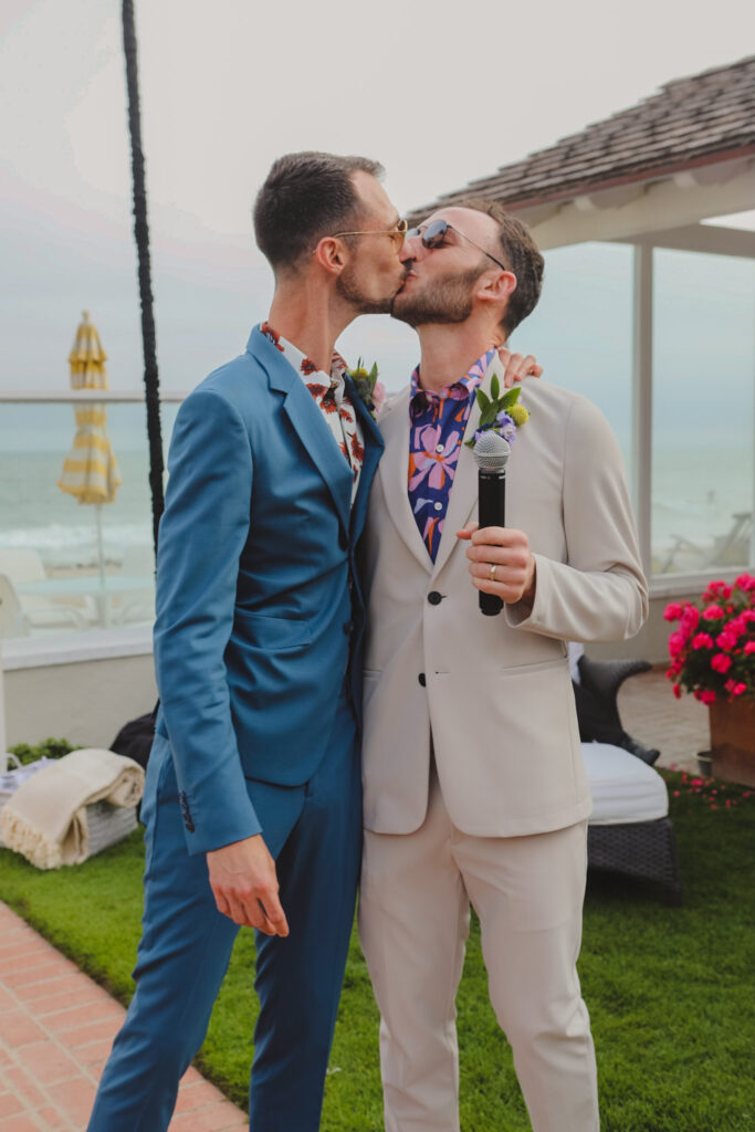 grooms kiss during wedding reception at private beach house