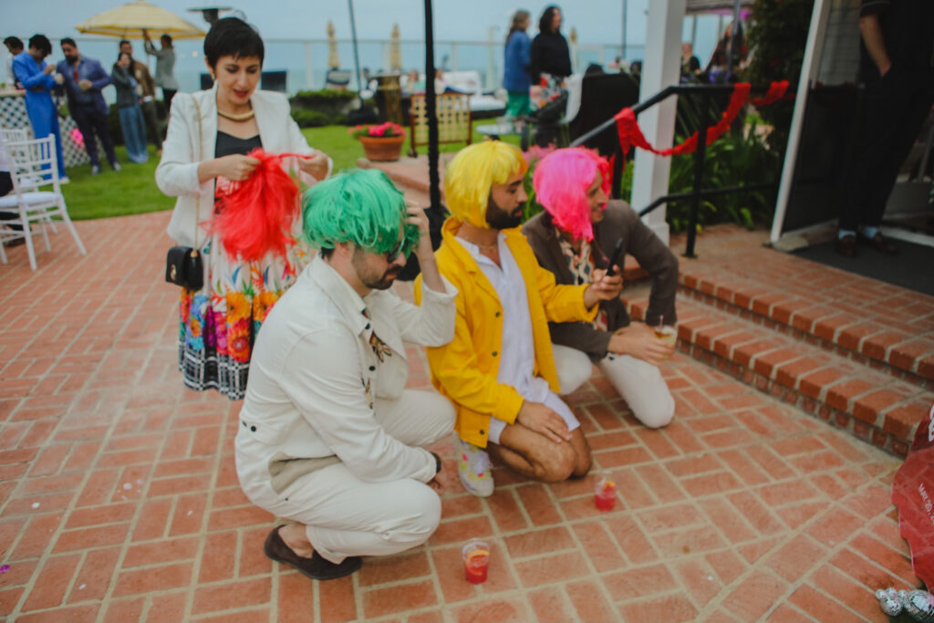 wedding guests in colorful wigs at wedding reception 