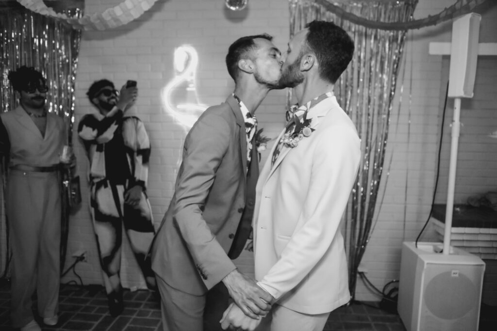 black and white photo of two grooms kissing during first dance