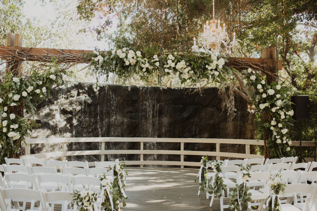 waterfall wedding ceremony at The Oak Room at Calamigos Ranch with white floral arrangements 