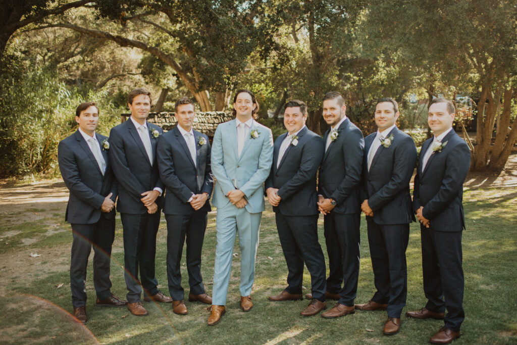 groom in light blue suit with groomsmen in dark grey suits