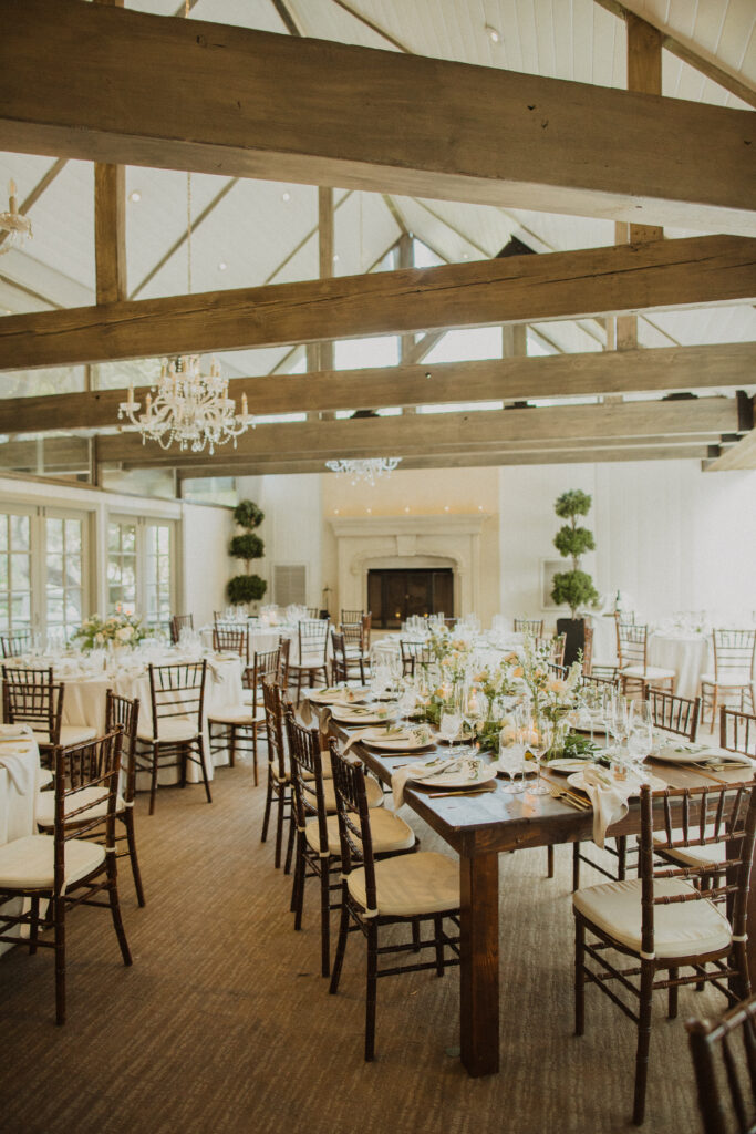 soft gold wedding reception at the Oak Room at Calamigos Ranch with farm tables and white floral arrangements