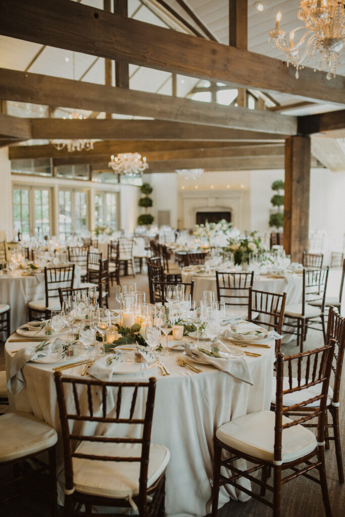 soft gold wedding reception at the Oak Room at Calamigos Ranch with white floral arrangements and gold cutlery 