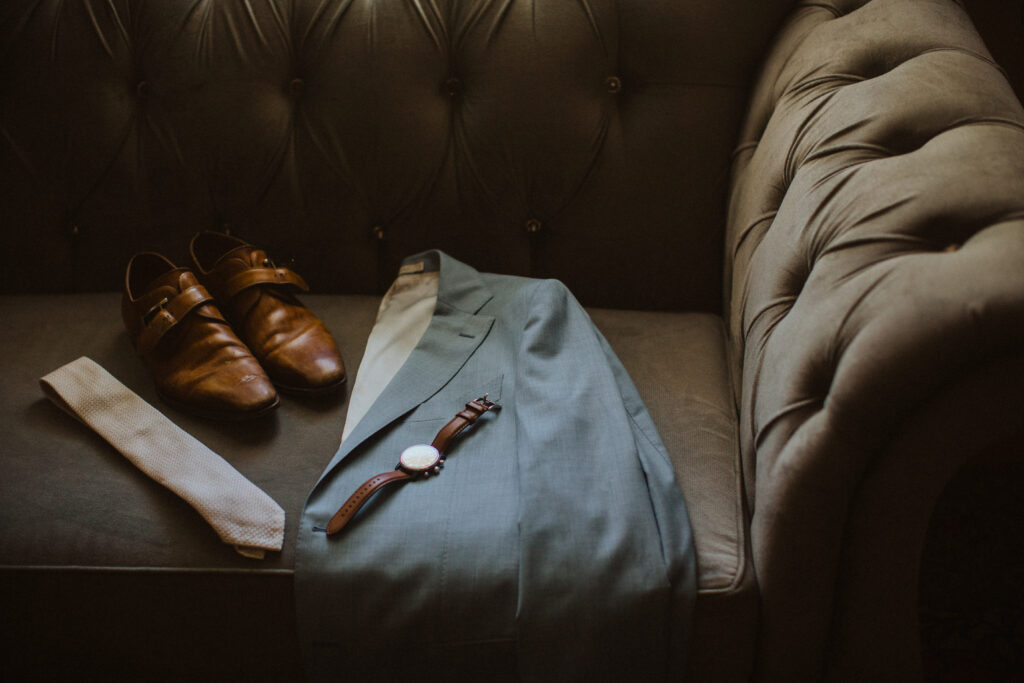 groom light blue suit jacket, brown watch and shoes