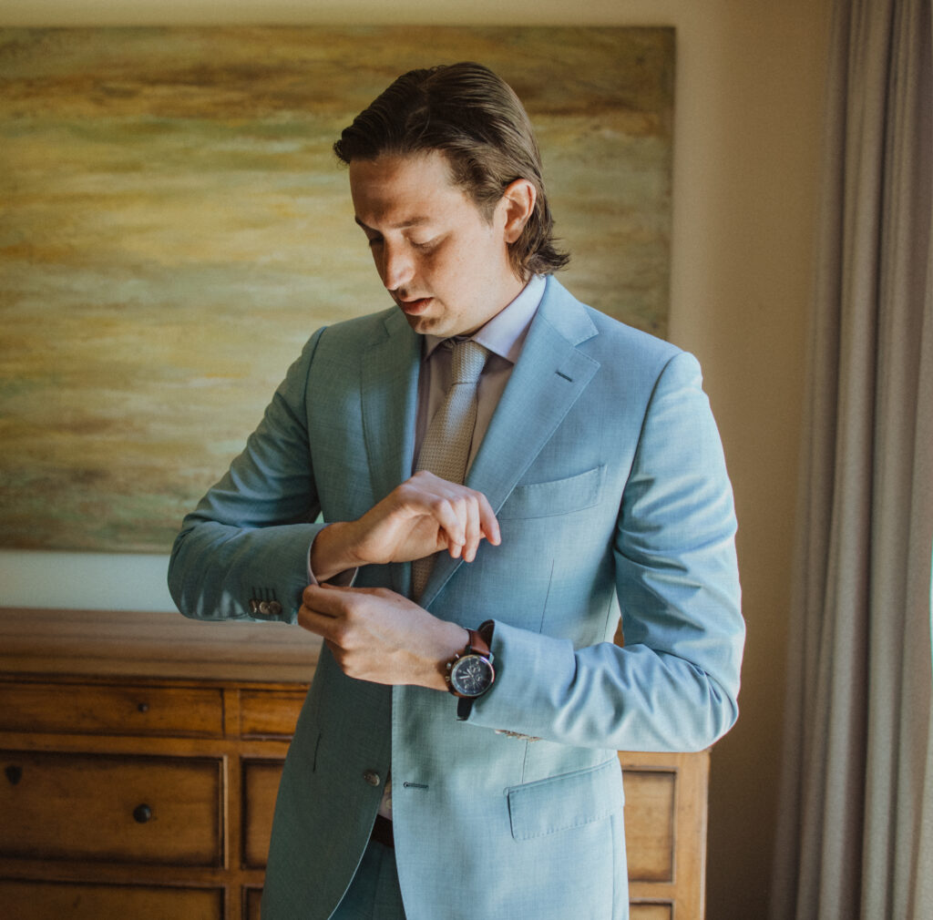 groom in light blue suit getting ready for wedding day