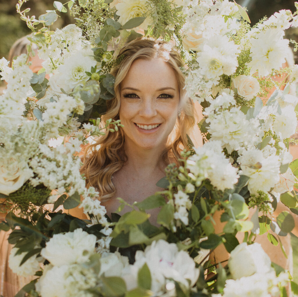 bride surrounded by white floral bouquets