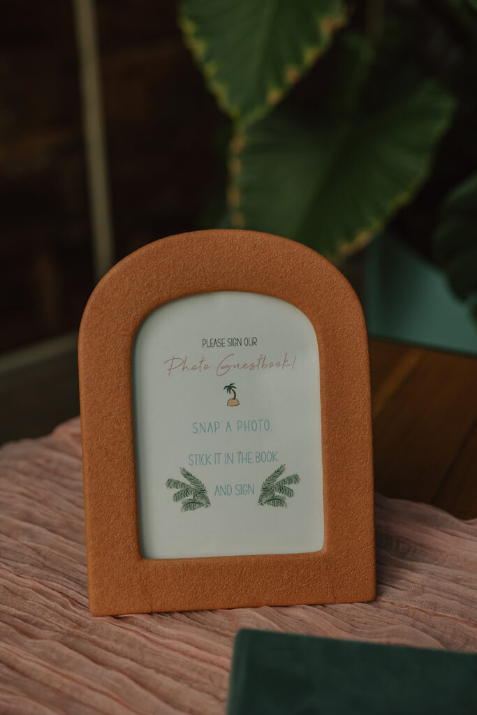 arched frame with photo guestbook instructions on wedding welcome table at DTLA