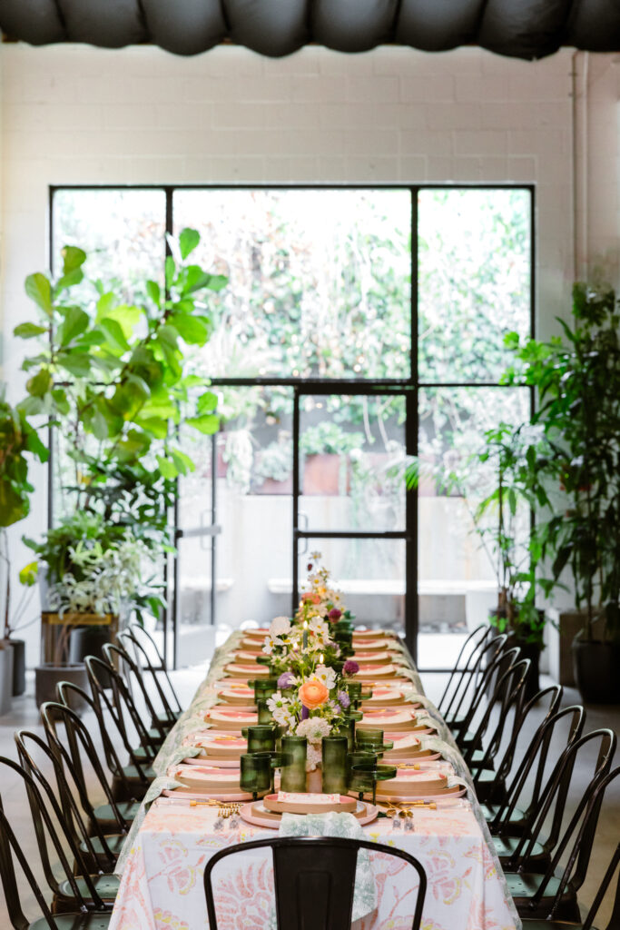 contemporary end of summer soiree dinner set up at Playa Studios with black modern dining chairs and bright floral table decor