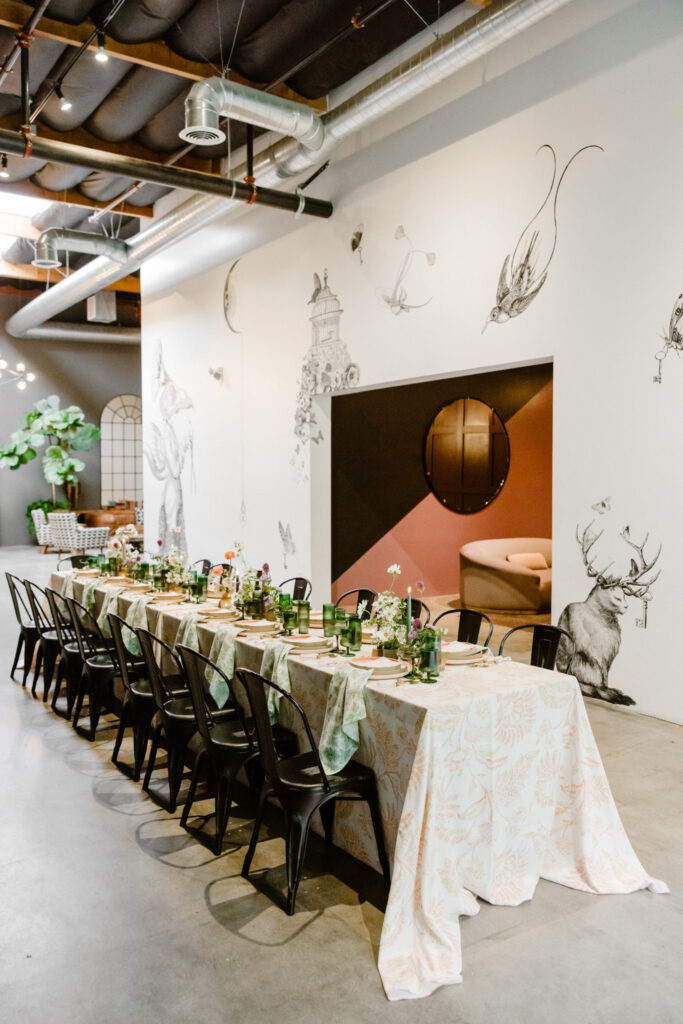 contemporary end of summer soiree dinner set up at Playa Studios with black modern dining chairs and bright floral table decor