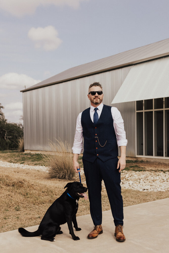groom in navy vest and white button up with pocket watch, holding dog