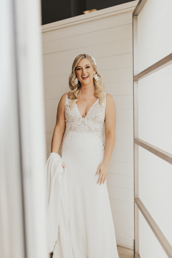 bride in deep v-neck wedding dress with lace elements and statement earrings