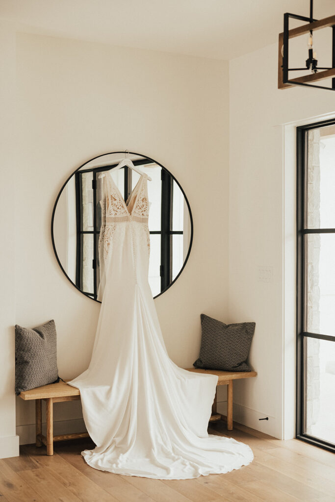deep vneck wedding dress with lace detailing hanging from mirror