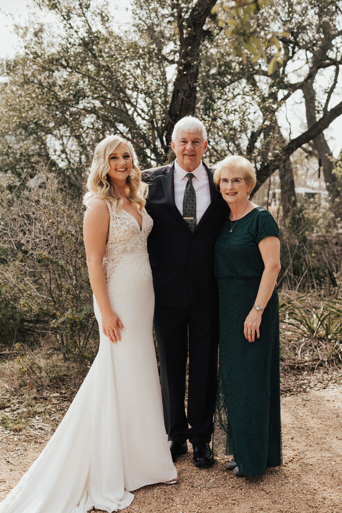 bride in deep v-neck wedding dress with lace details does first look with father and mother 