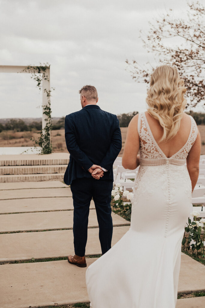bride in deep v-neck wedding dress with lace elements and groom in navy blue suit have first look at Prospect House destination wedding