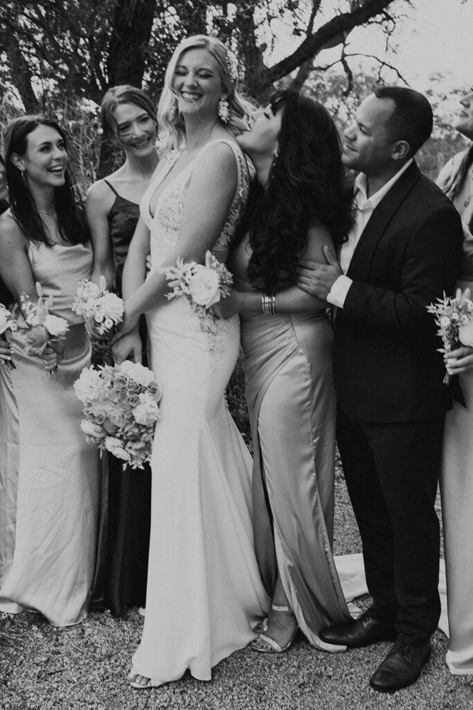bride in deep v-neck wedding dress with co-ed wedding party in dark green and champagne colored outfits