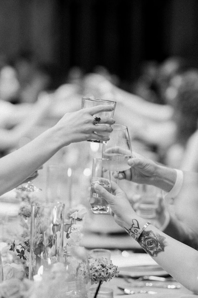 black and white photo of people cheering at wedding reception