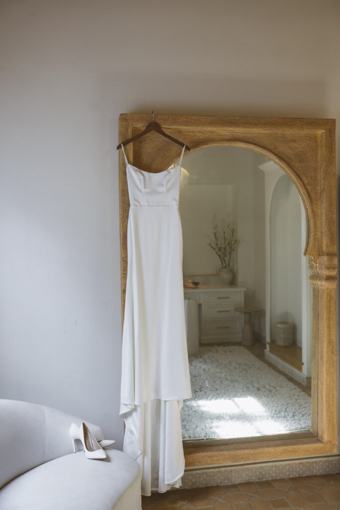 modern minimalist wedding dress hanging from mirror