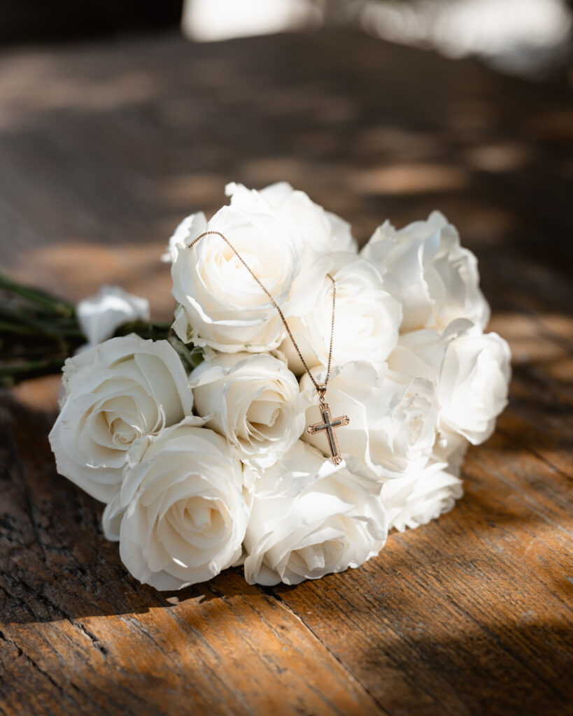 white rose bridal bouquet with cross necklace 
