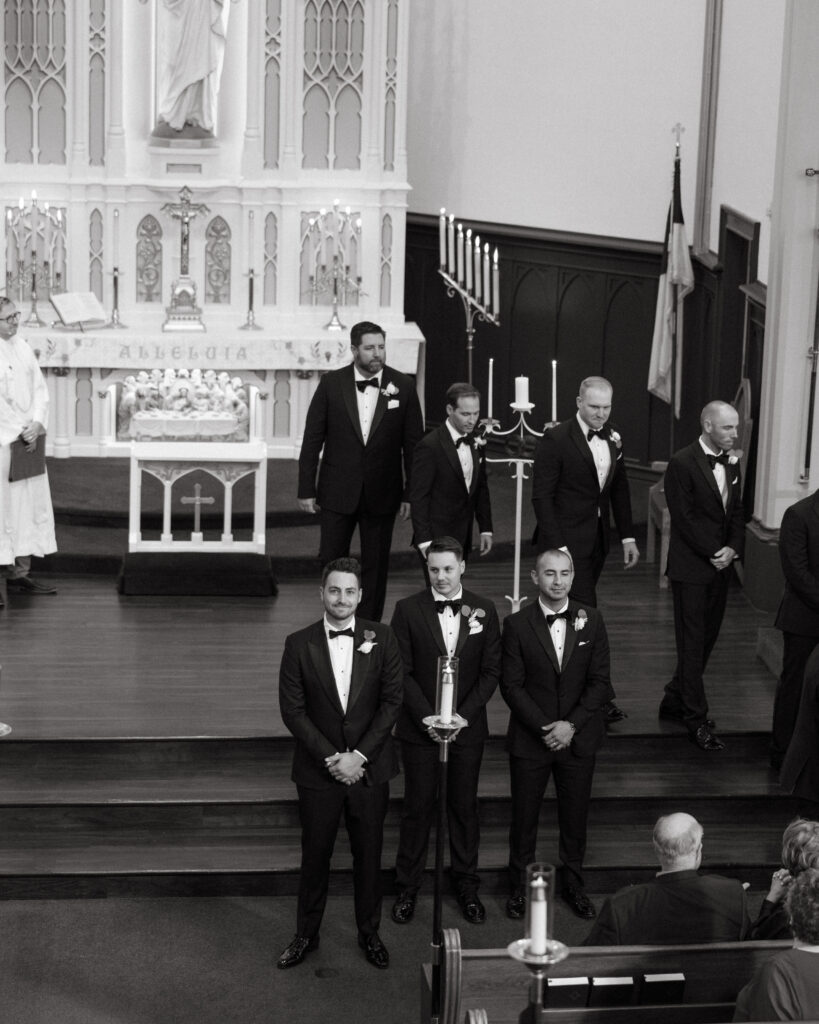 groom and groomsmen standing during church wedding ceremony
