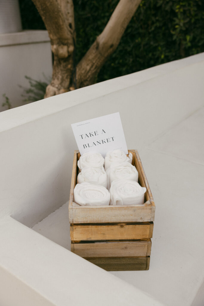 small basket with white blankets for wedding cocktail hour