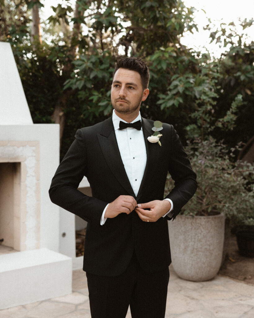 groom in classic black tuxedo suit with bowtie 