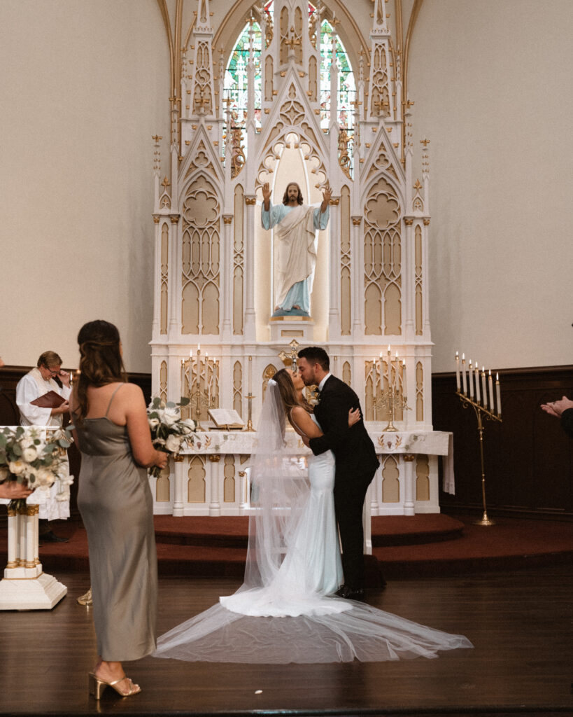 bride and groom first kiss during church wedding cermony