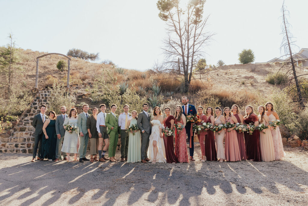 bride and groom with co-ed wedding party in mixed green and red outfits