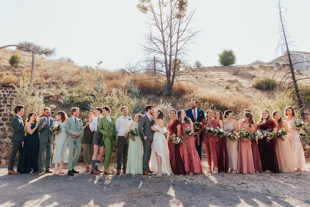 bride and groom with co-ed wedding party in mixed green and red outfits