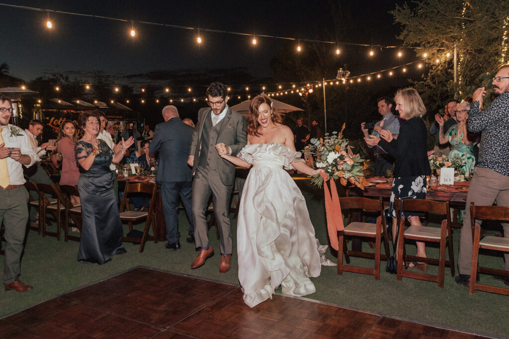 bride and groom enter wedding reception for first dance