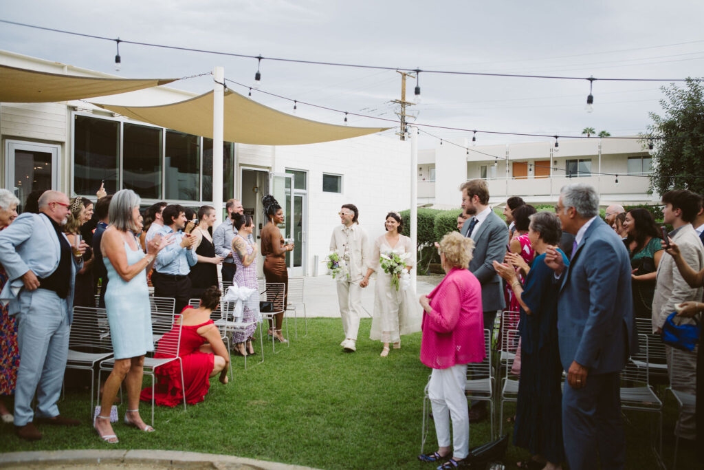 laid back cool wedding ceremony at Ace Hotel with bride and groom walking down aisle together