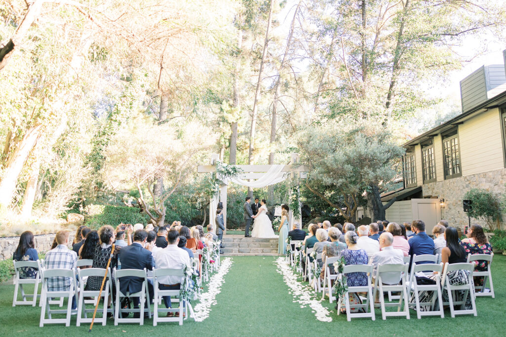 light and airy wedding ceremony at Calamigos Redwood Room with white drapery and flowers