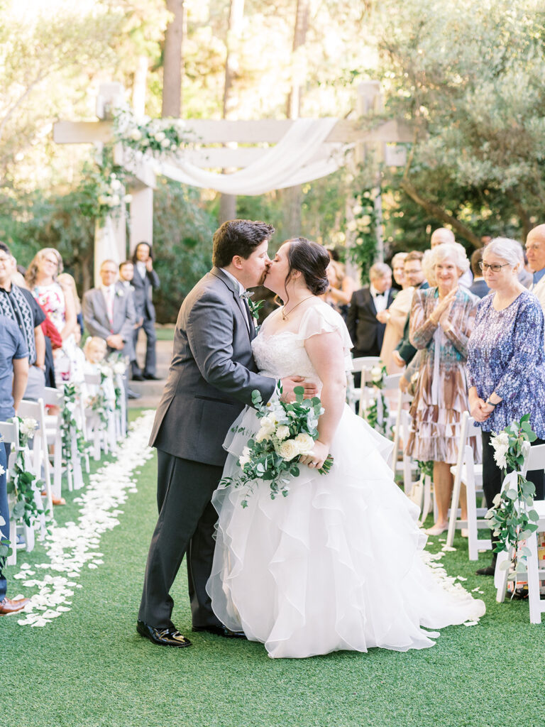 bride and groom recessional during light and airy wedding ceremony at Calamigos Redwood Room with white drapery and flowers