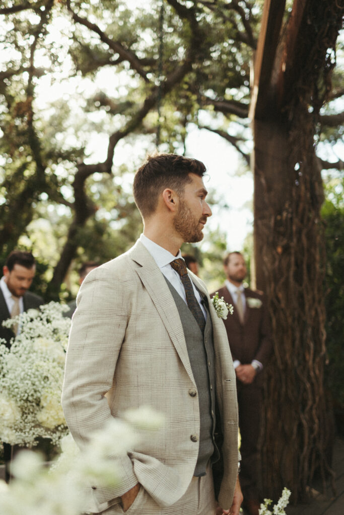 groom in khaki plaid suit during wedding ceremony