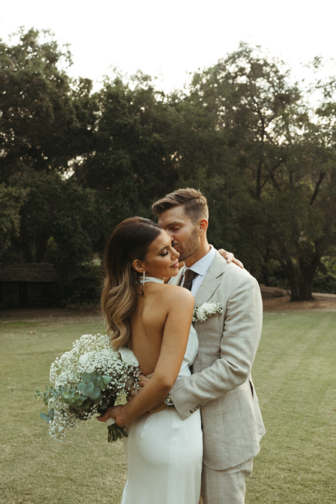 bride in satin halter style wedding dress and groom in khaki plaid suit portrait photos at Calamigos Ranch