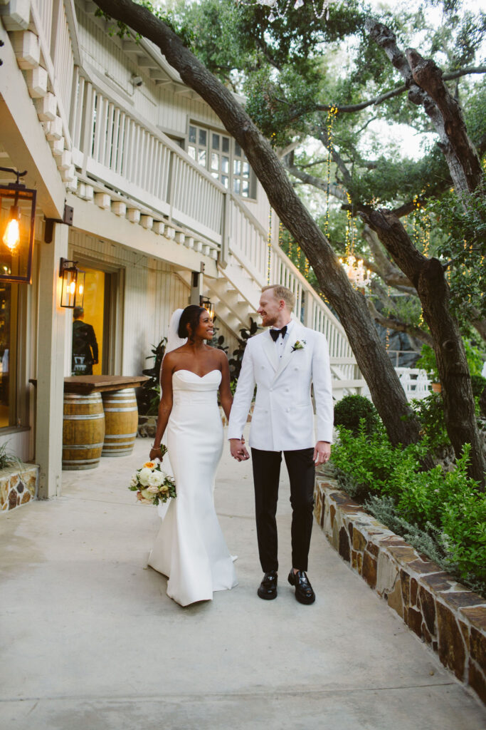 bride in modern minimalist wedding dress and cathedral veil with groom in white tuxedo jacket at Calamigos Ranch 