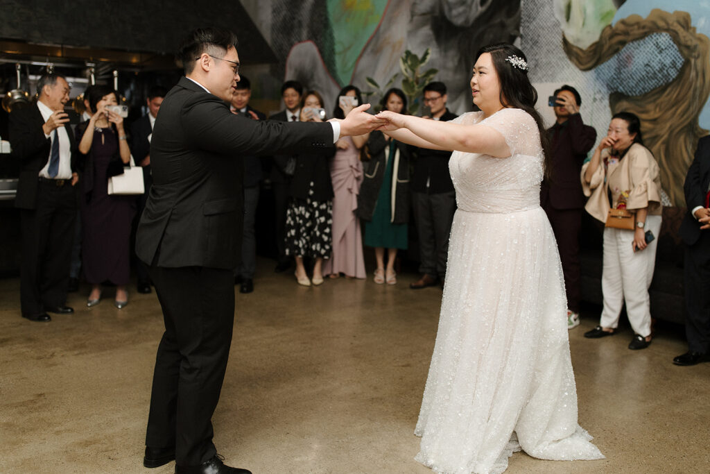 bride in beaded shutter sleeve wedding dress and groom in black suit have first dance | Feathered Arrow Studio, Los Angeles wedding planner